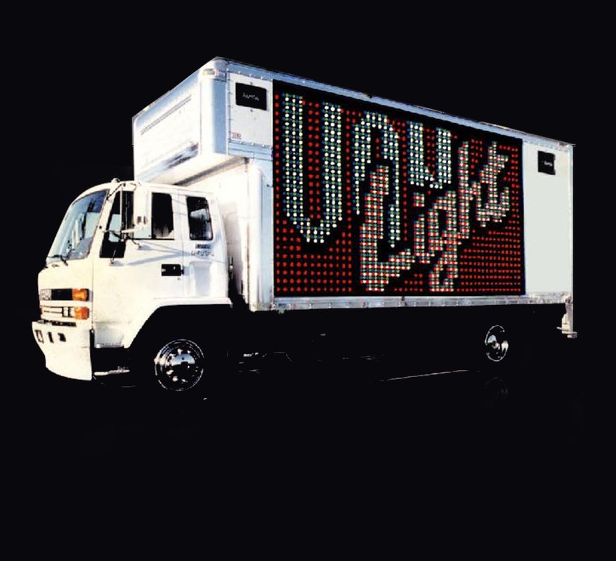 The Sign Bus: a white truck with a sign made of light bulbs on its side